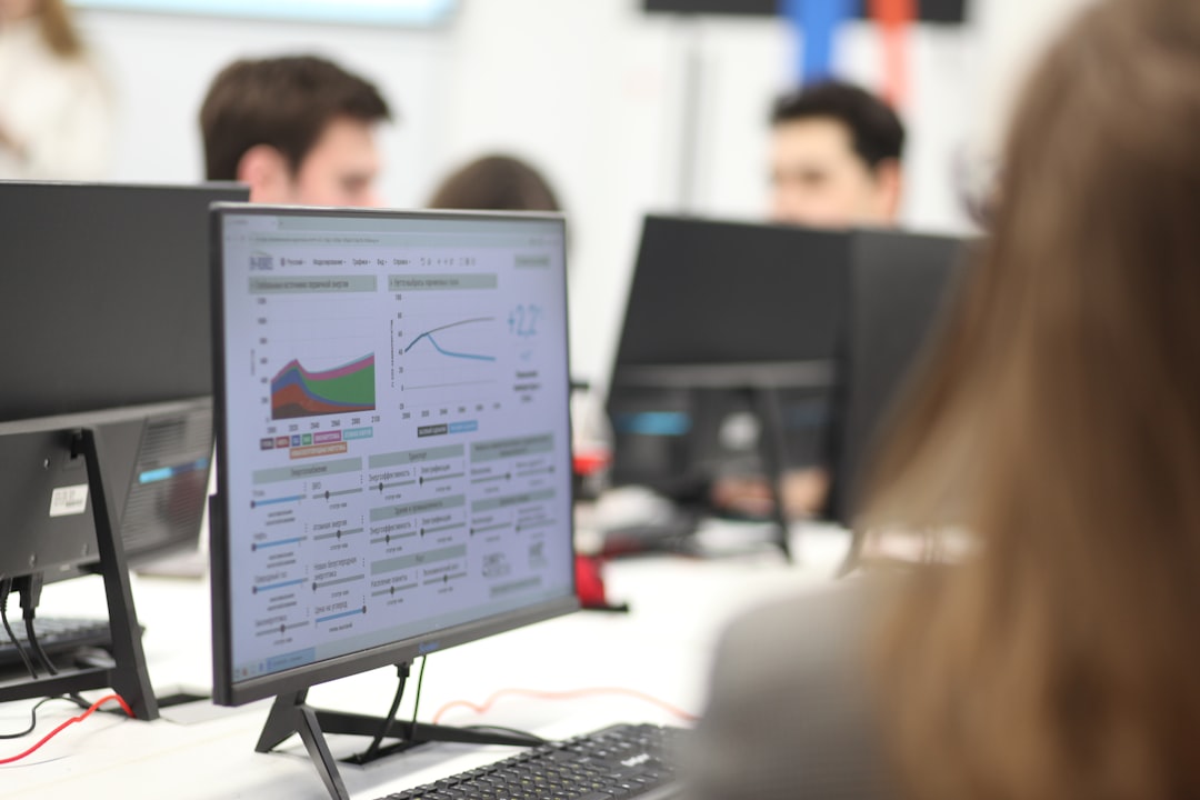 Profissionais analisando dados e métricas em telas, representando a análise de indicadores de engajamento